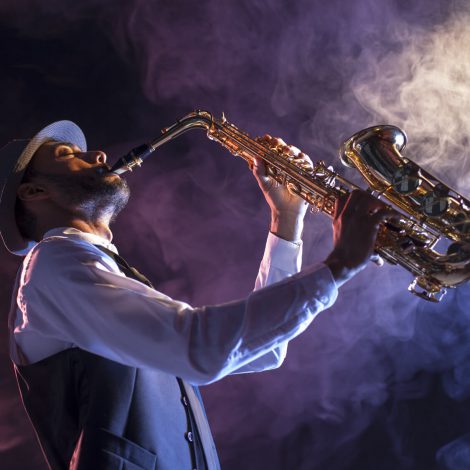 Saxofonista sobre escenario con humo