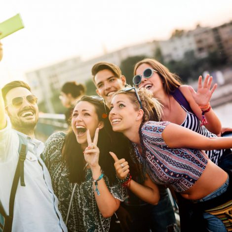 Happy young people taking selfies in city