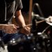 music, people, musical instruments and entertainment concept - male musician playing drums and cymbals at concert or studio